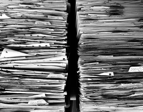 Duas pilhas de papéis alinhadas e divididas por datas demonstram a importância da organização de documentos para uma gestão financeira eficiente.
